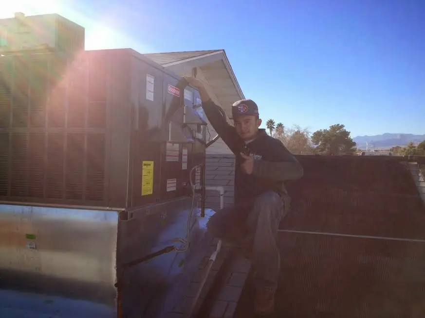HVAC technician performing Air Duct Cleaning on a rooftop unit in Mount Airy
